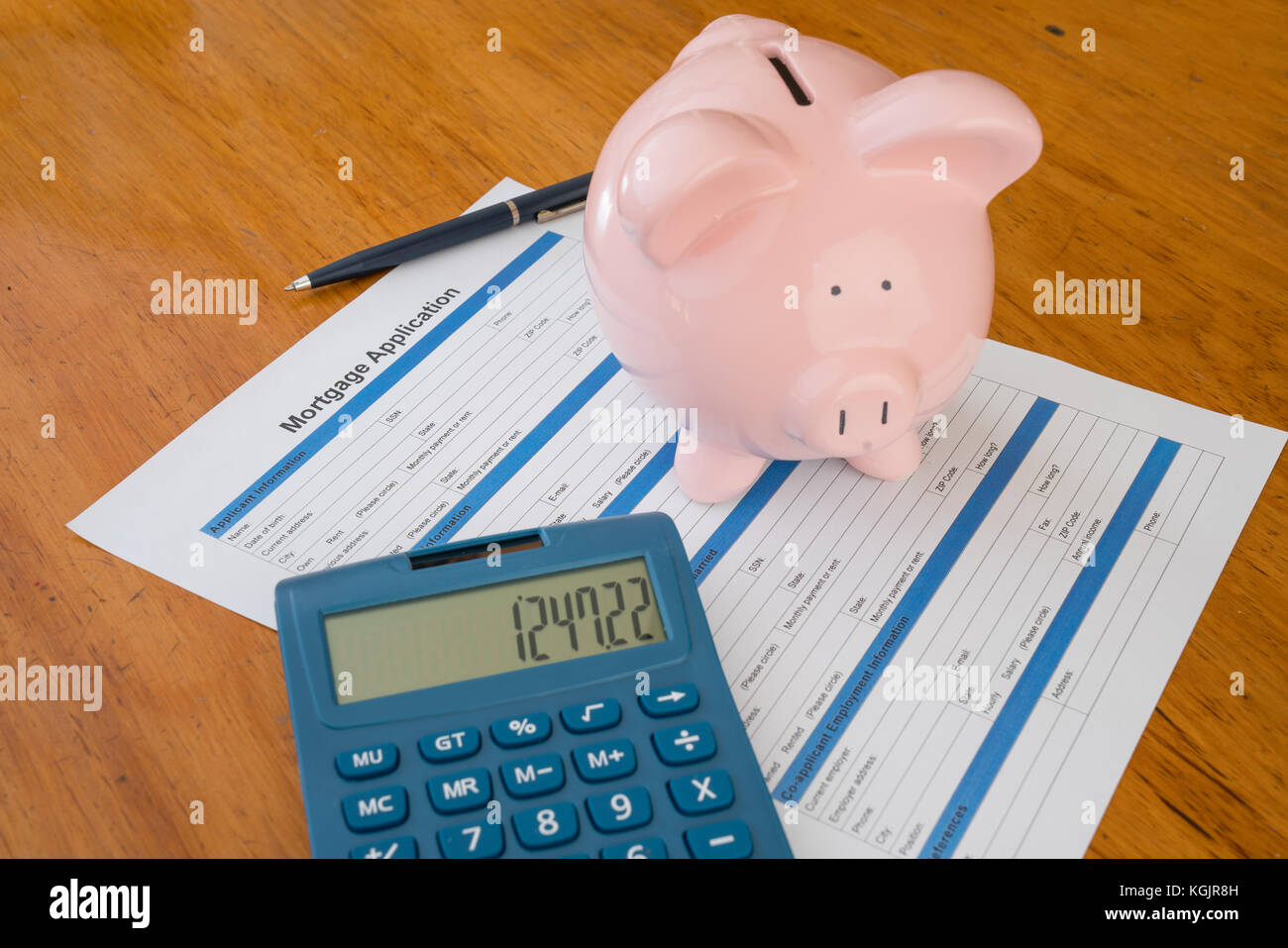 Hypothek Anwendung auf Schreibtisch mit Sparschwein, Taschenrechner und Kugelschreiber Stockfoto