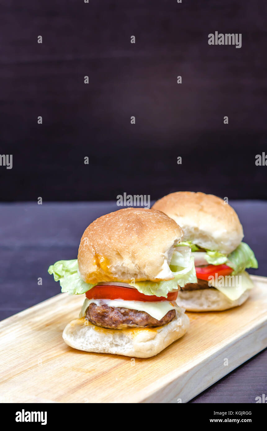 Leckere hausgemachte gourmet Käse Burger aus Rindfleisch mit frischen Zutaten auf Holz- Platten platziert Stockfoto