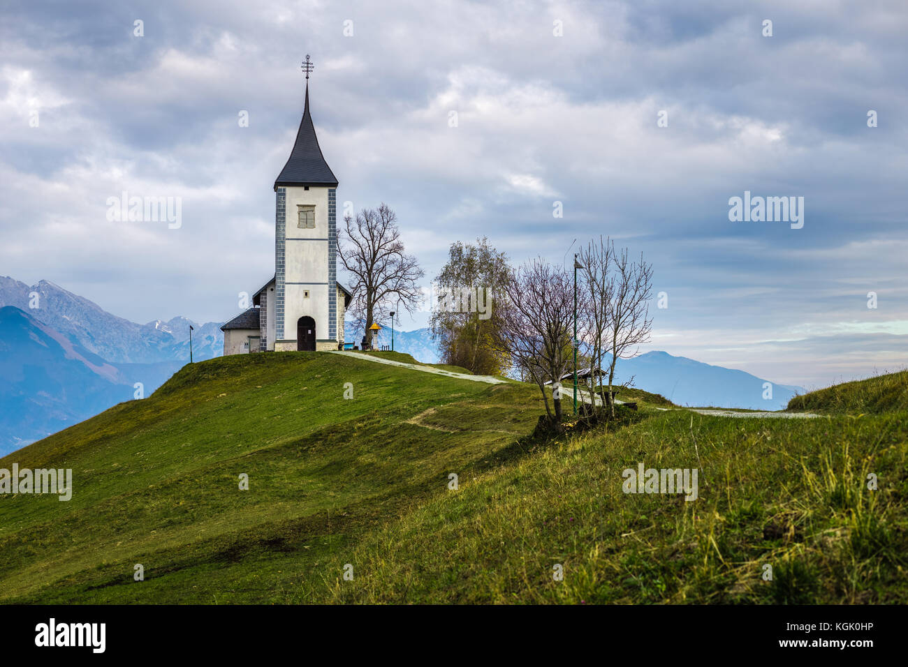Jamnik, Slowenien - Die schöne Kirche St. Primoz in Slowenien bei Jamnik mit Julischen Alpen im Hintergrund Stockfoto