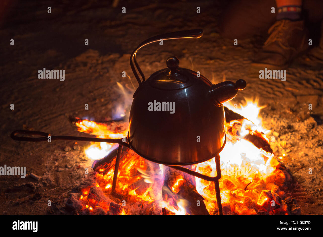 Wasserkocher kochendes Wasser auf ein Lagerfeuer in der Nacht Stockfoto