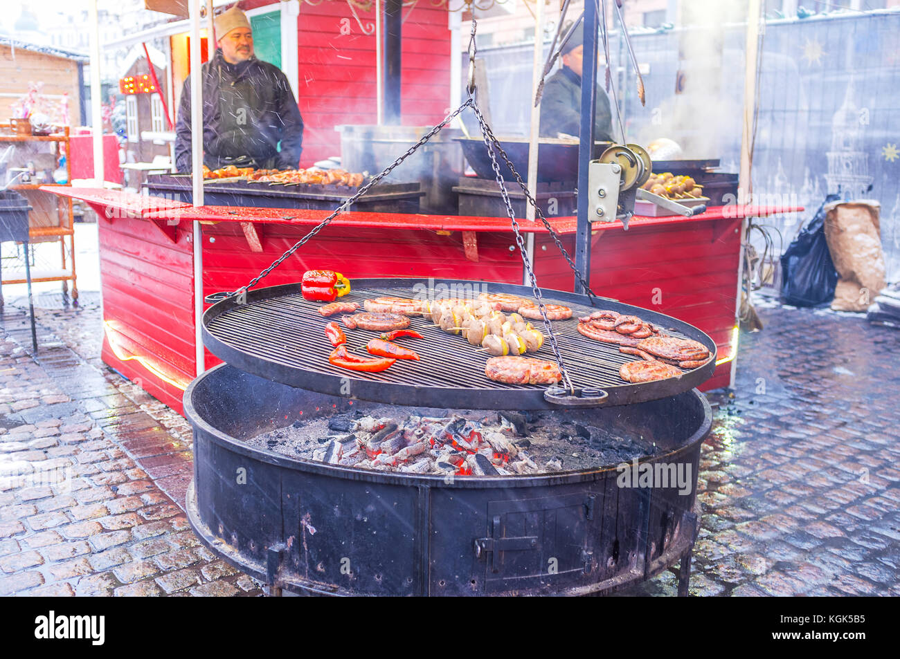 KIEW, UKRAINE - 4. JANUAR 2017: Der Grill auf dem Weihnachtsmarkt mit duftenden Würstchen, Frankfurts, Kartoffeln auf Spießen und Paprika zieht Besucher an Stockfoto