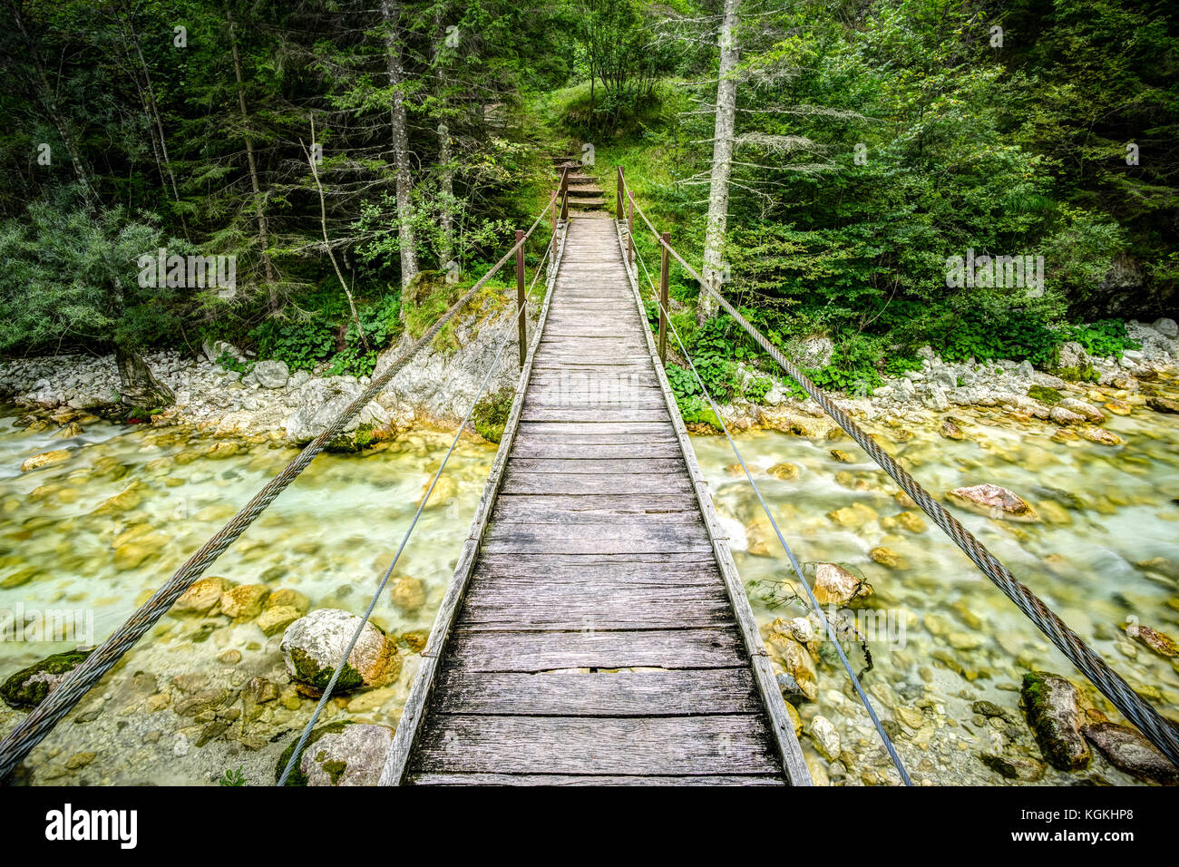 Alte hölzerne Planke Brücke über Fluss. die Überwindung eines Hindernisses Konzept. Stockfoto