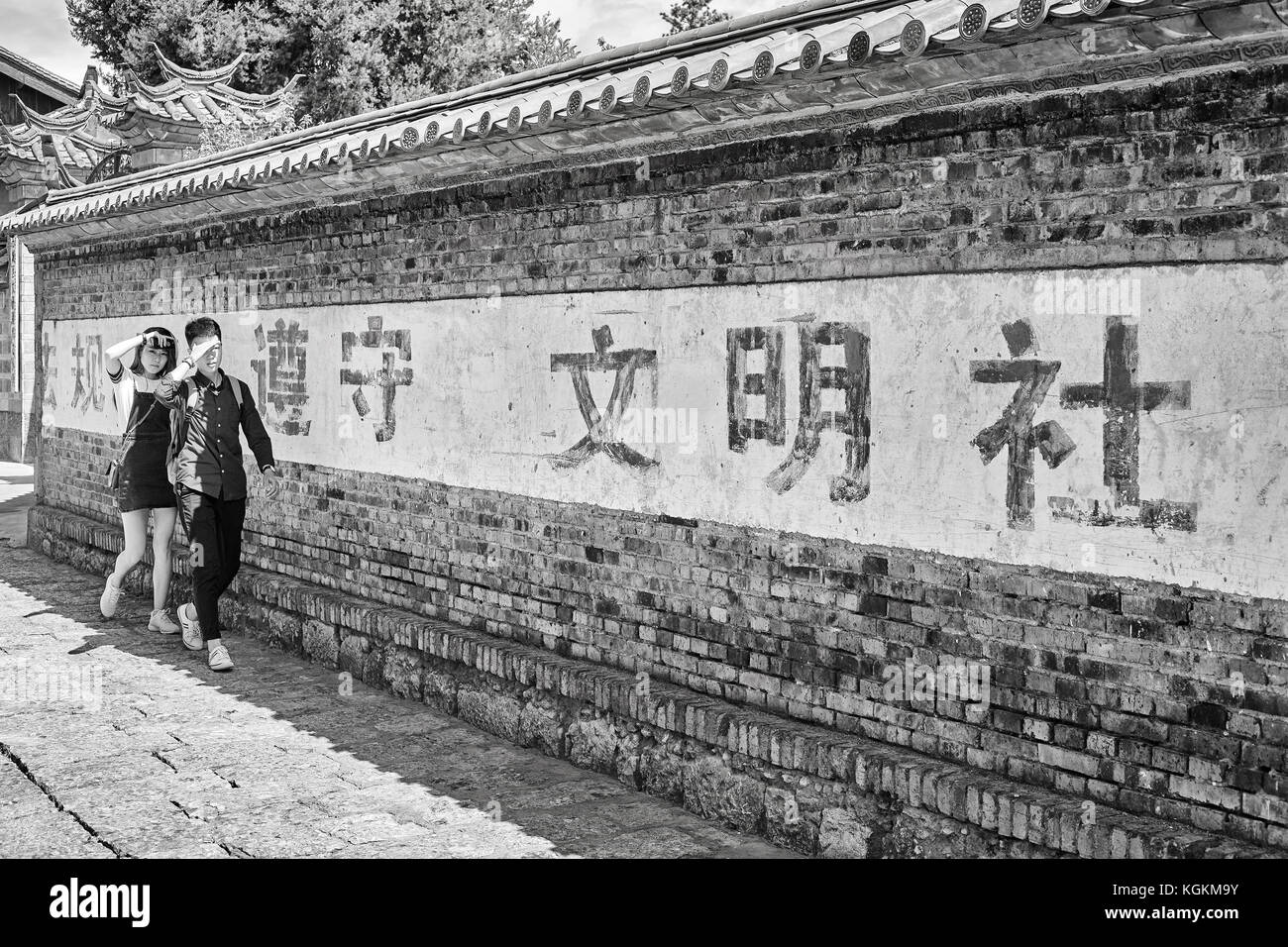 Lijiang, Yunnan, China - 28. September 2017: Junge chinesische Spaziergang im Schatten der Dayan wall. Altstadt von Lijiang ist ein UNESCO-Weltkulturerbe. Stockfoto