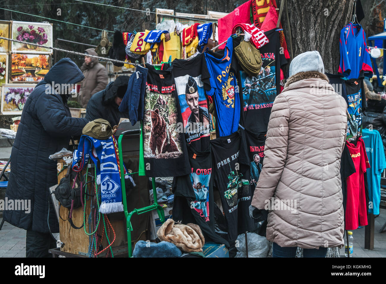 Frau auf der Suche nach t-shirts mit Wladimir Putin in einem kleinen Markt im Zentrum von Chisinau, Republik Moldau, Dezember 2015 Stockfoto