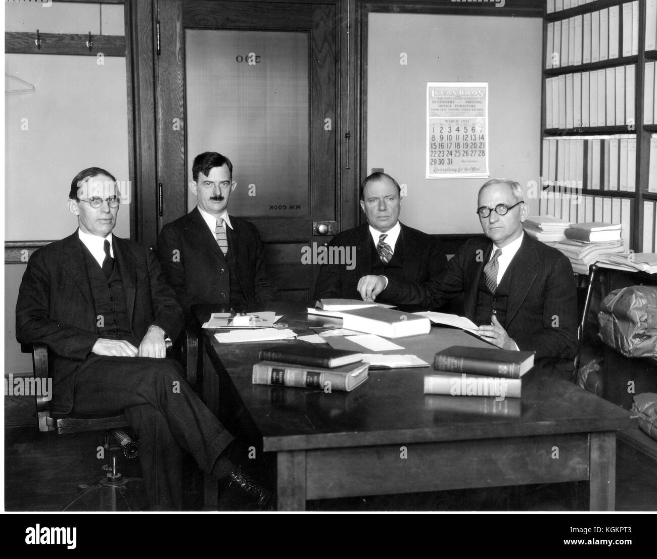 Gruppenfoto von Johns Hopkins Law Professoren Walter Cook, Hessel Yntema, Leon Marshall und Herman Oliphant, die an einem Tisch sitzen, mit offenen Büchern in Cooks Büro, März 1931. Stockfoto