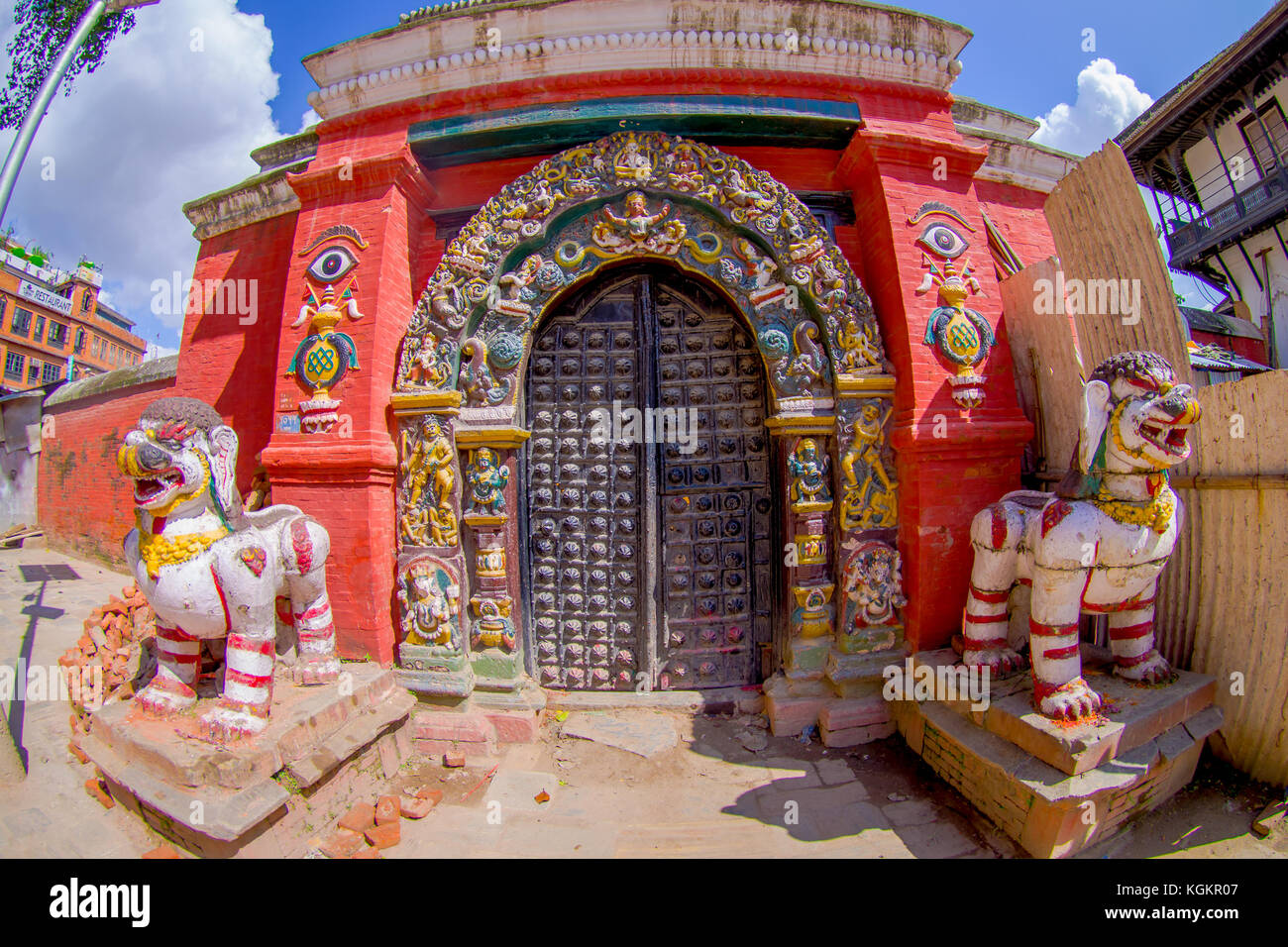 Kathmandu, Nepal Oktober 15, 2017: in der Nähe von zwei gesteinigt Aufsichtspersonen, sich die von einem Tempel geben, mit einigen geschnitzte Struktur, in der die Tür und der Rahmen der Eingabe des Gebäudes, in den Wiederaufbau nach dem Erdbeben im Jahr 2015 Der Durbar Square in Kathmandu, der Hauptstadt von Nepal Stockfoto