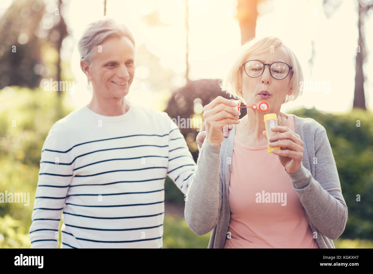 Erfreut, intelligente Frau mit einem seifenblasen Flasche Stockfoto