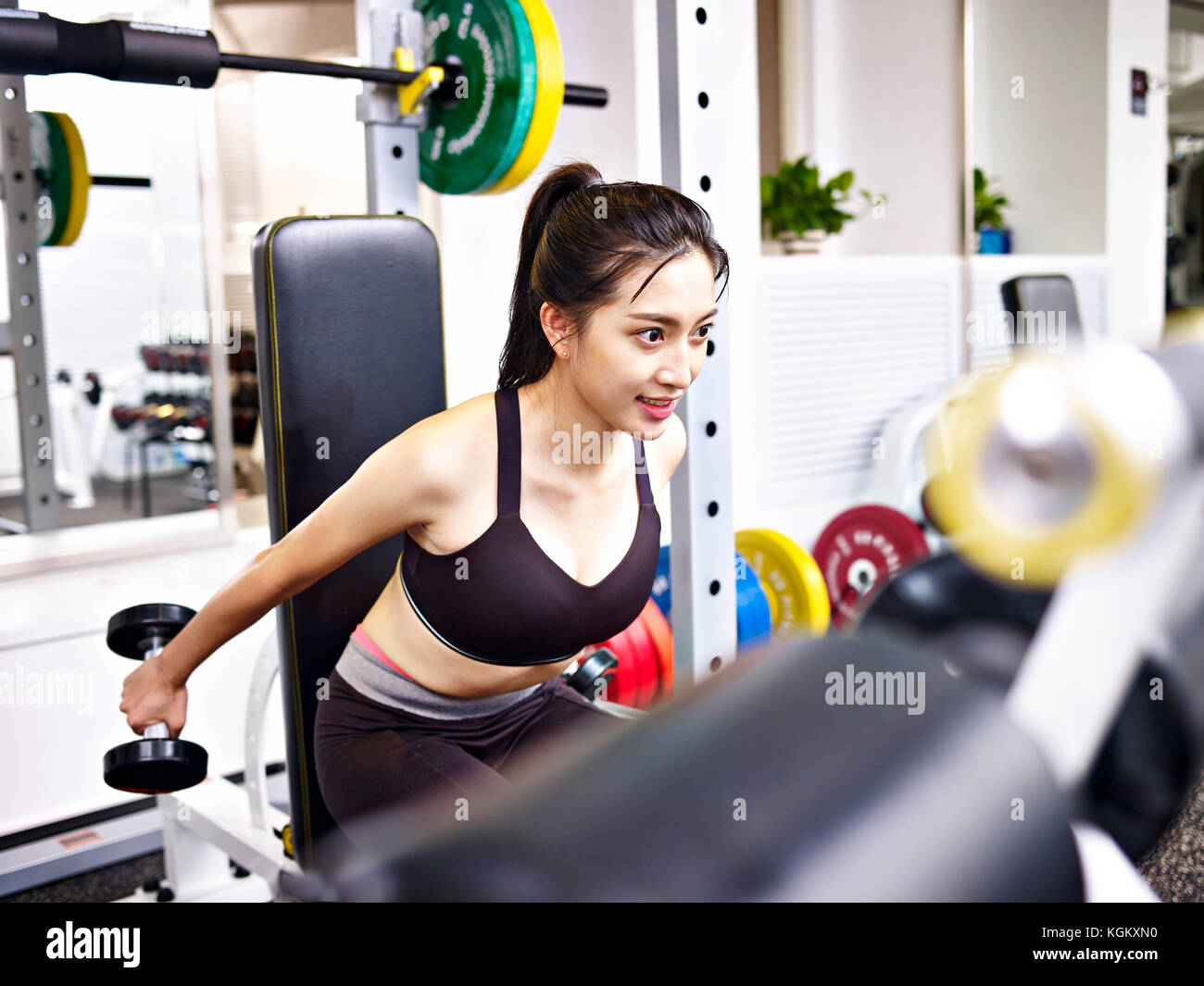 Junge asiatische Frau, trainieren Sie im Fitnessraum mit Hanteln. Stockfoto