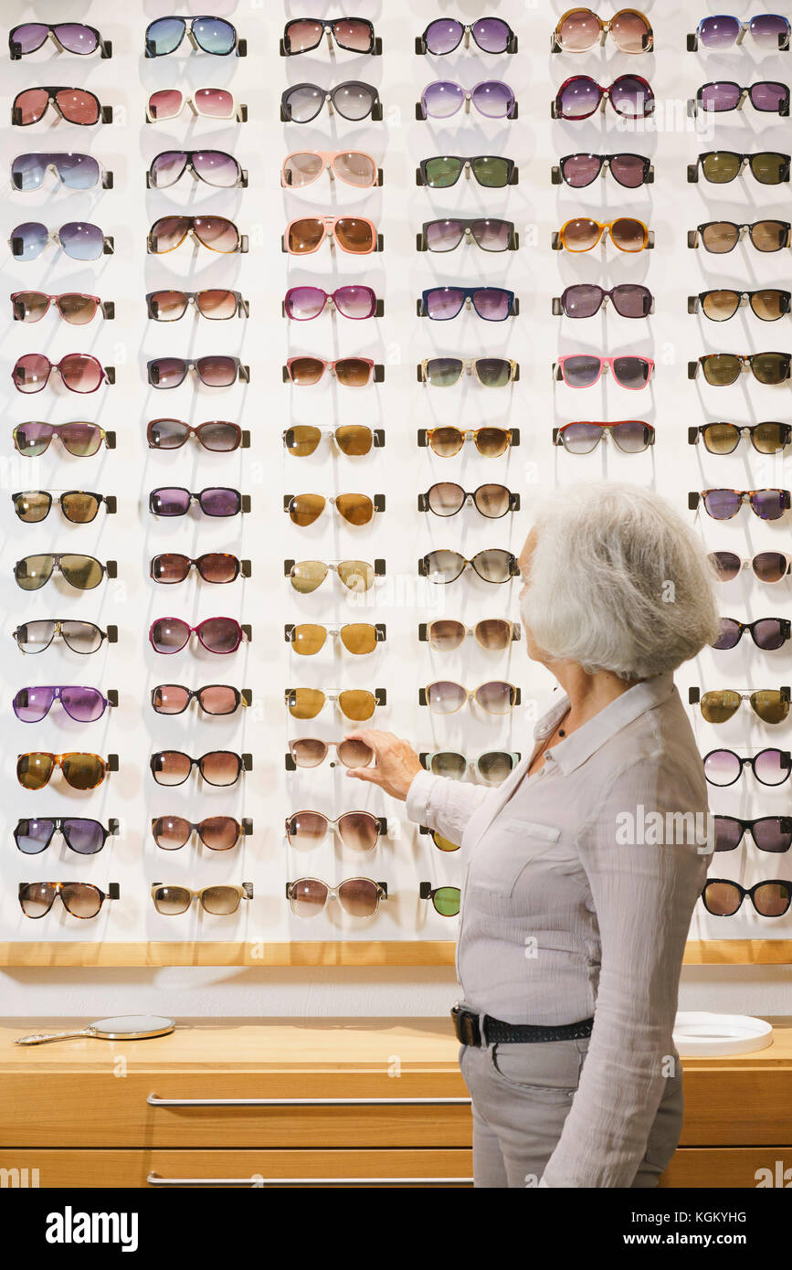 Seitenansicht der älteren Frau mit Sonnenbrille bei Store Stockfoto