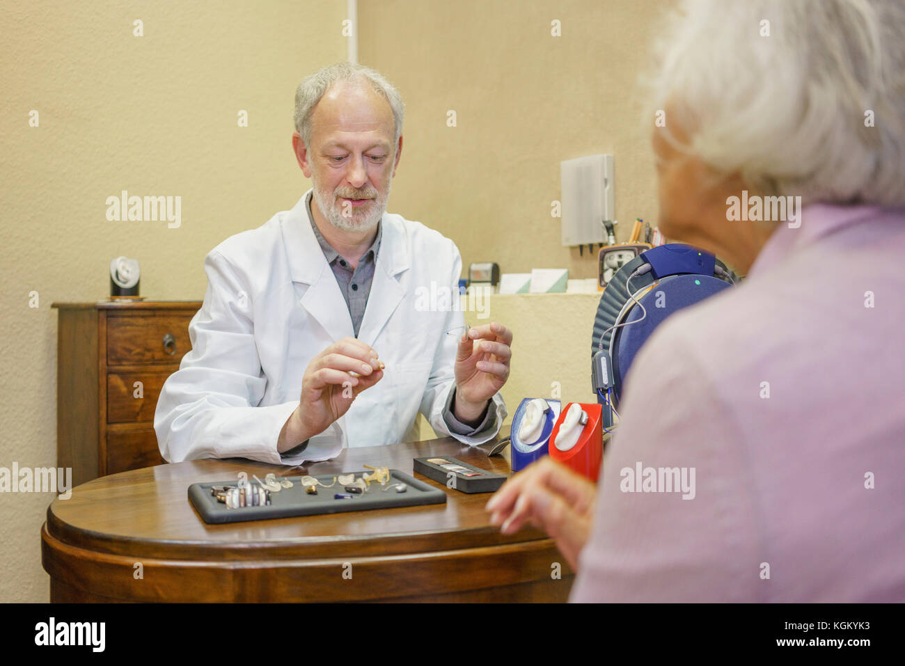 Arzt mit Hörgeräten zu erklären, ältere Frau an der Klinik Stockfoto