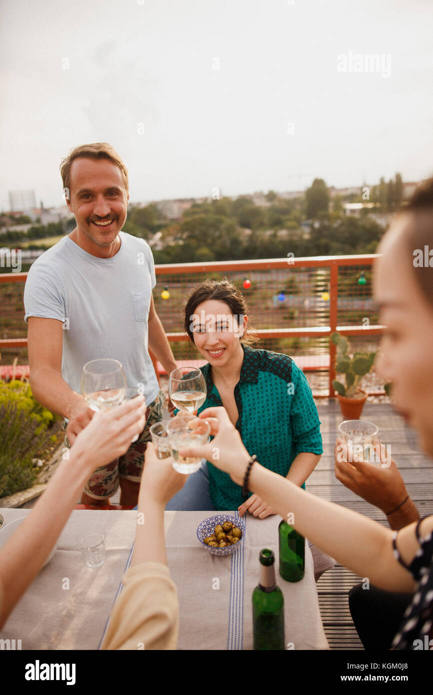 Gerne Freunde toasten Weingläser auf Tisch im Freien auf der Terrasse Stockfoto