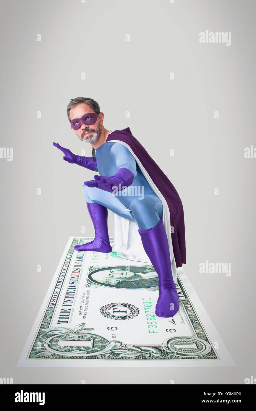 Superhelden biegen mit ausgestreckten Armen und Beinen auf künstlichen Amerikanischen Dollar Stockfoto