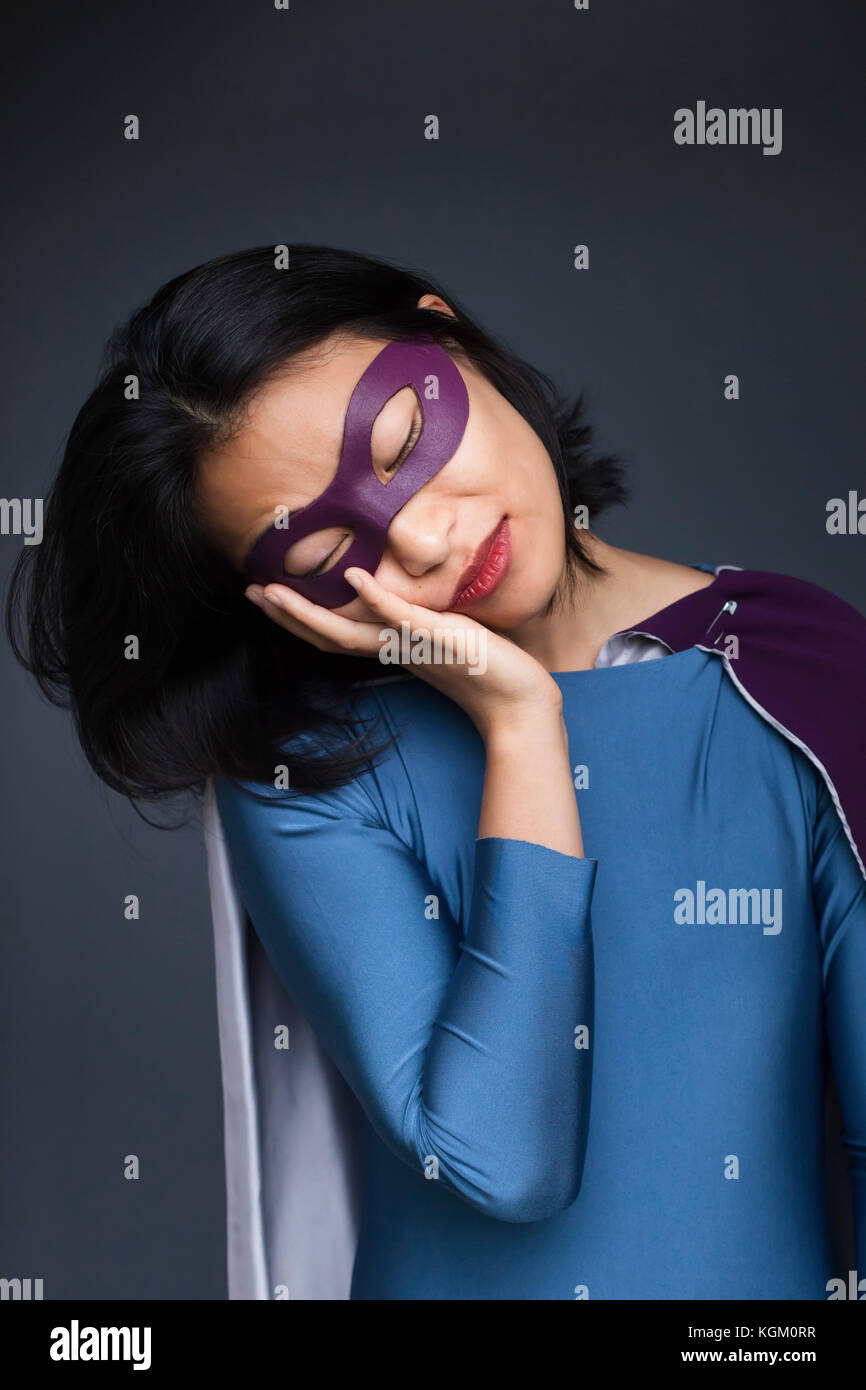 Weibliche Superheld gegen grauen Hintergrund napping Stockfoto Weibliche Superheld gegen grauen Hintergrund napping Stockfoto