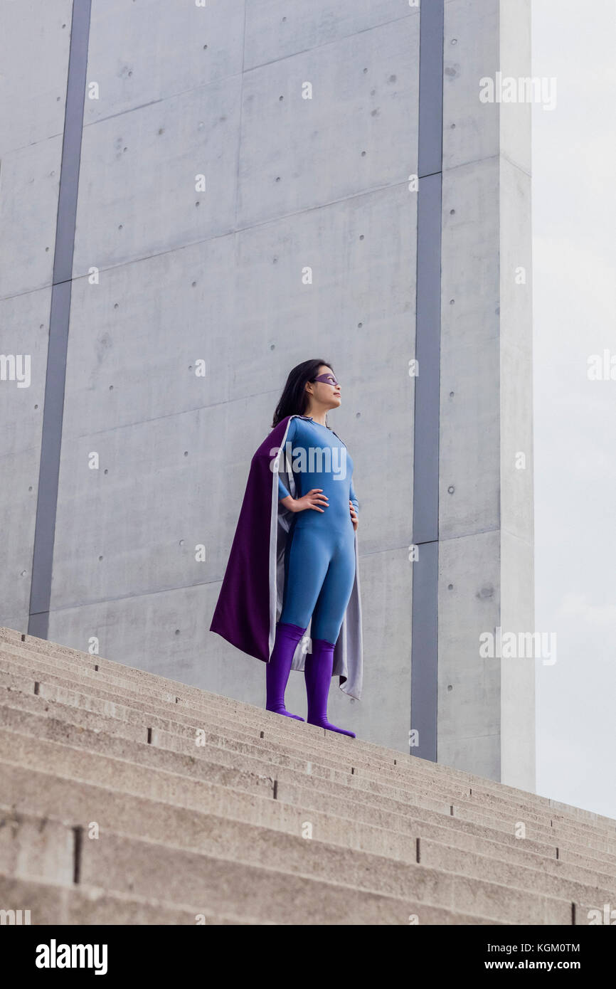 Low Angle View der weiblichen Superhelden auf Schritte gegen die Wand Stockfoto