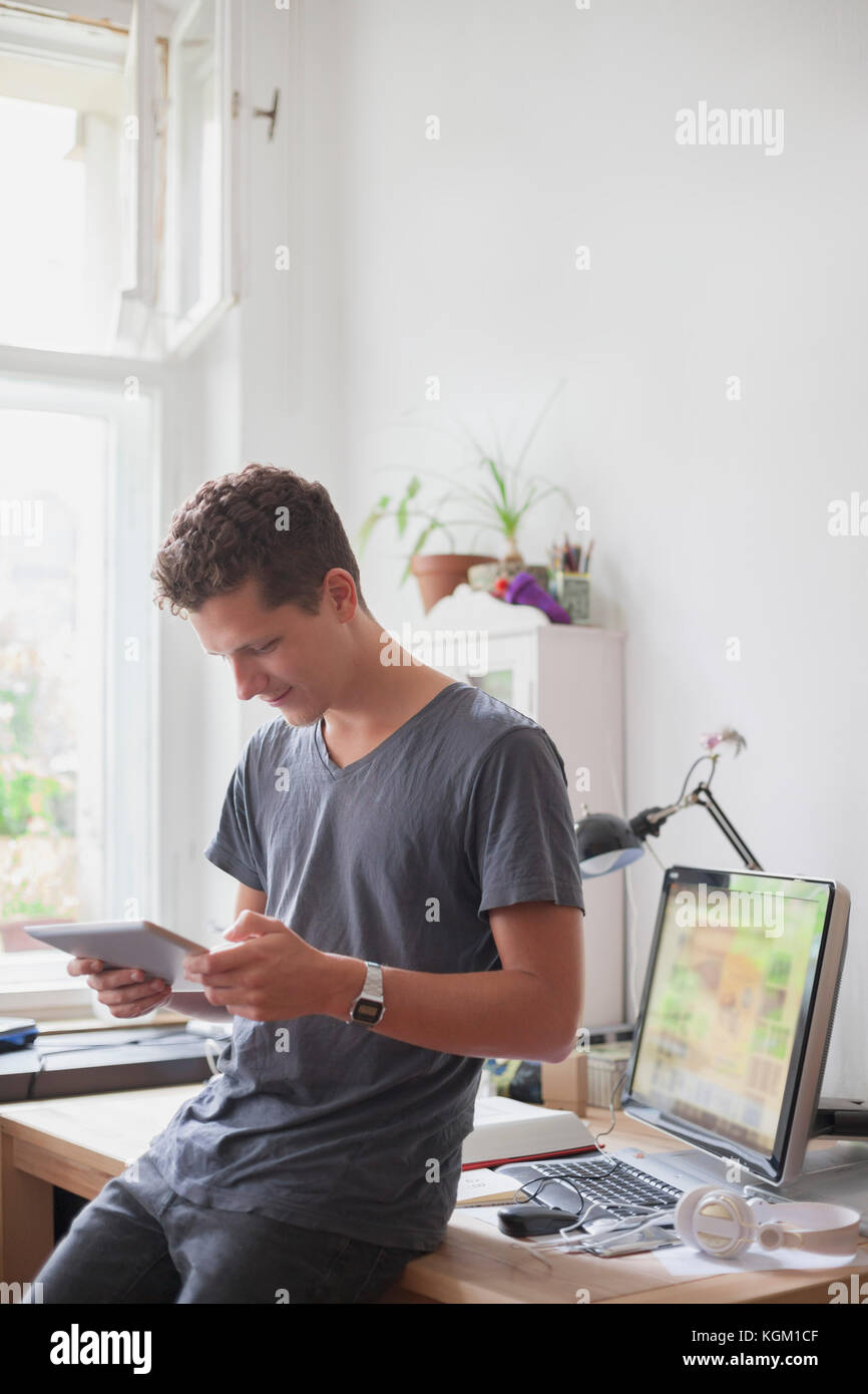 Junge männliche Studenten mit digitalen Tablette zu Hause Stockfoto