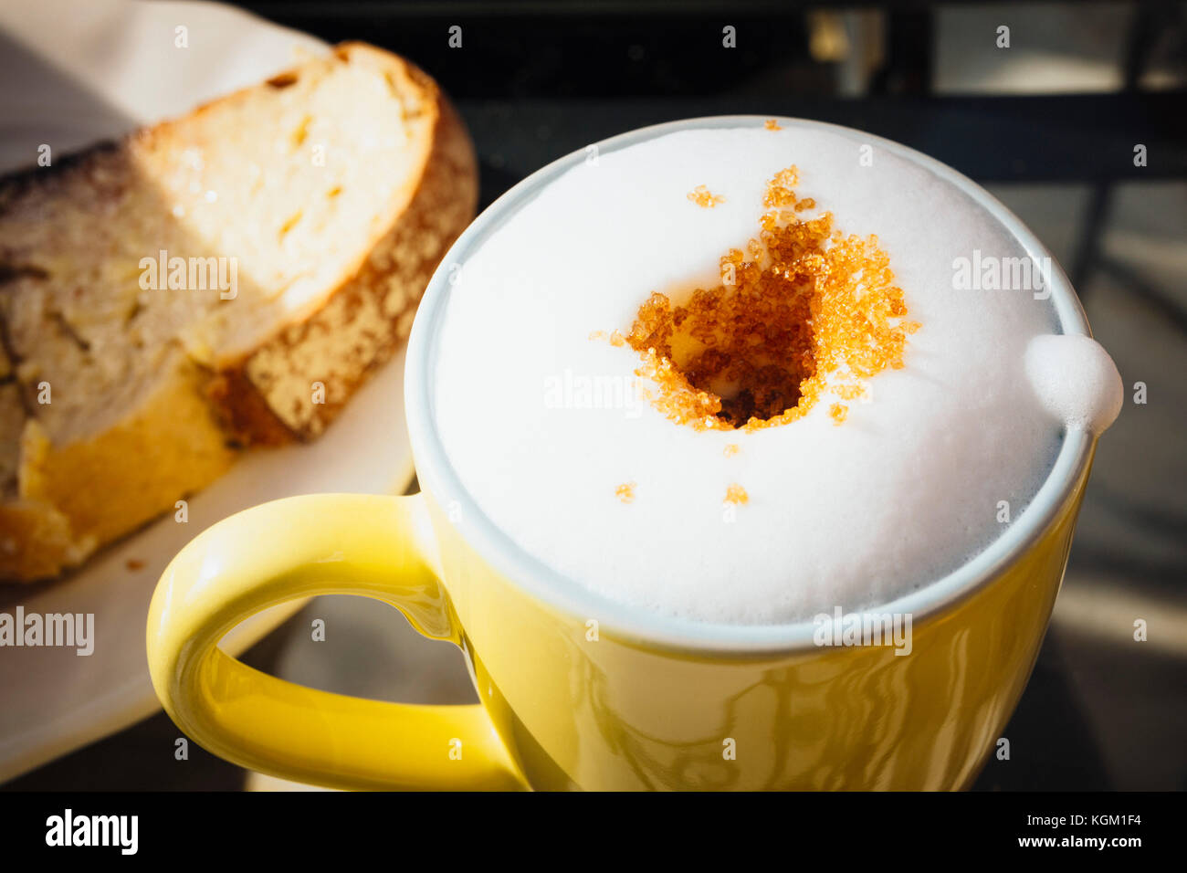 Hohe Betrachtungswinkel von frischem schaumigen Kaffee mit braunem Zucker auf Tisch im Cafe Stockfoto