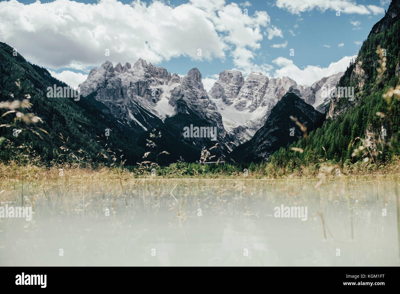 Malerischer Blick auf Feld gegen Rocky Mountains an einem sonnigen Tag, Südtirol, Italien Stockfoto