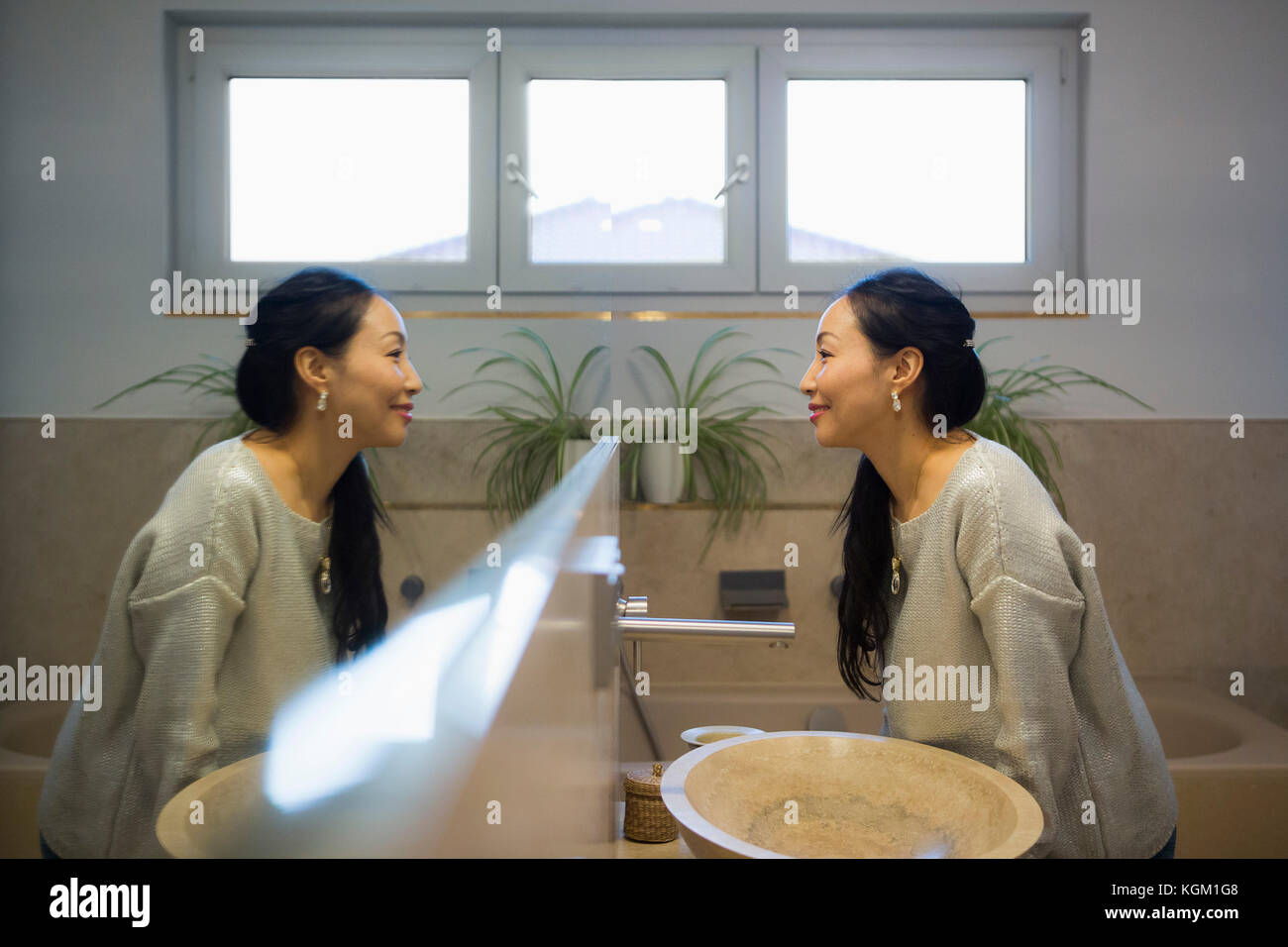 Seitenansicht der lächelnden reife Frau im Spiegel Reflexion in Bad Stockfoto