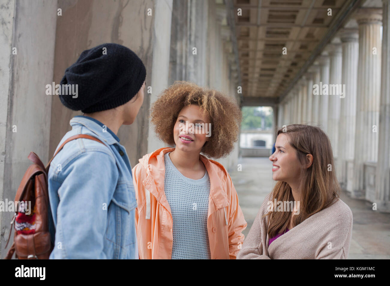 Junge multi-ethnischen Freunde sprechen beim Stehen in der Flur, Berlin, Deutschland Stockfoto