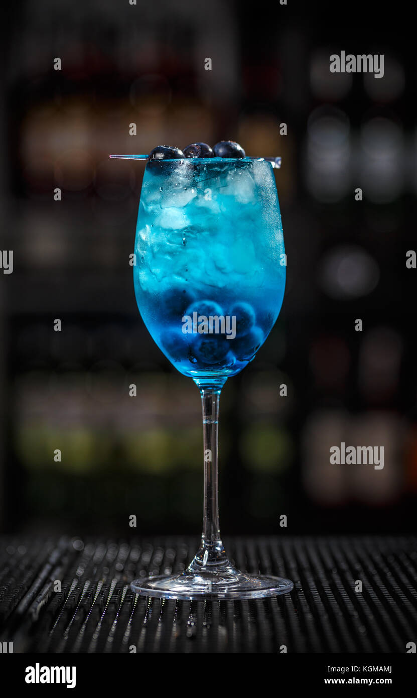 Glas blaue Lagune cocktail dekoriert mit Cranberry Stockfoto