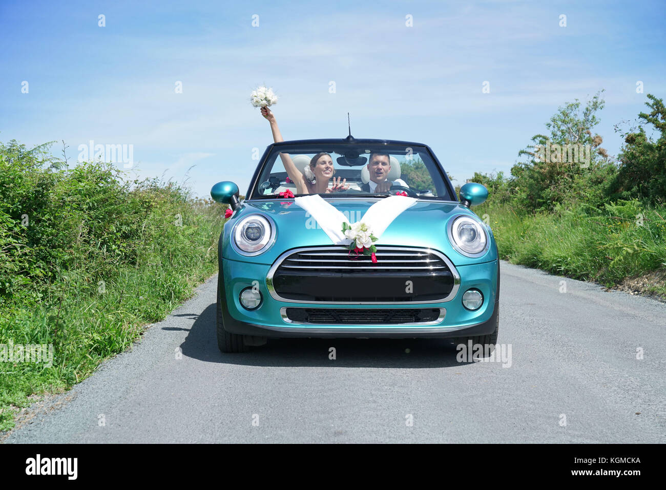 Frisch verheiratete Ehepaar fahren Cabrio Stockfoto
