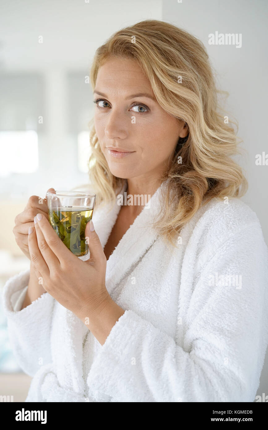 Porträt der attraktive 40-jährige Frau im Bademantel trinken Infusion Stockfoto