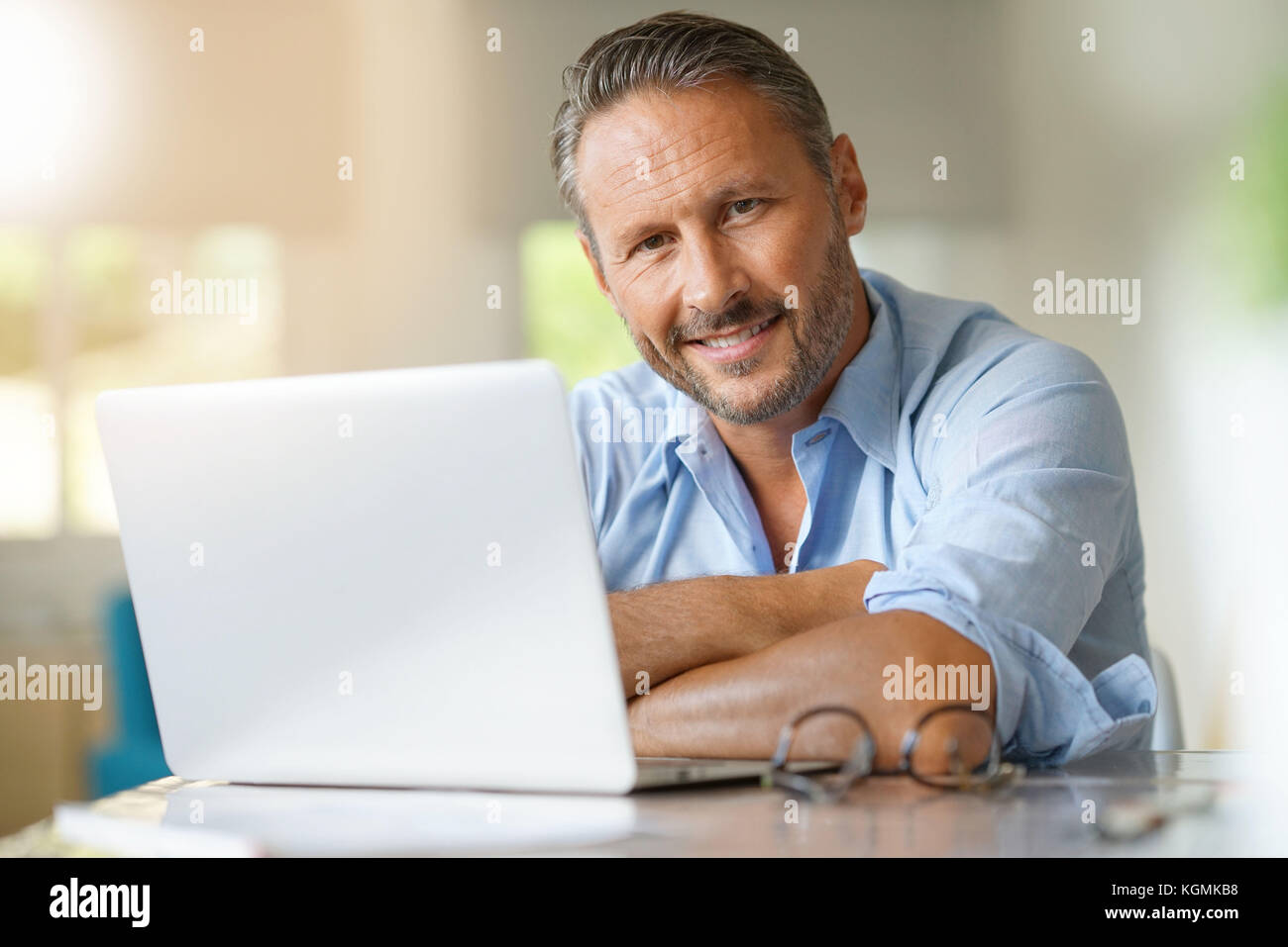 Reifer Mann am Laptop zu Hause arbeiten Stockfoto