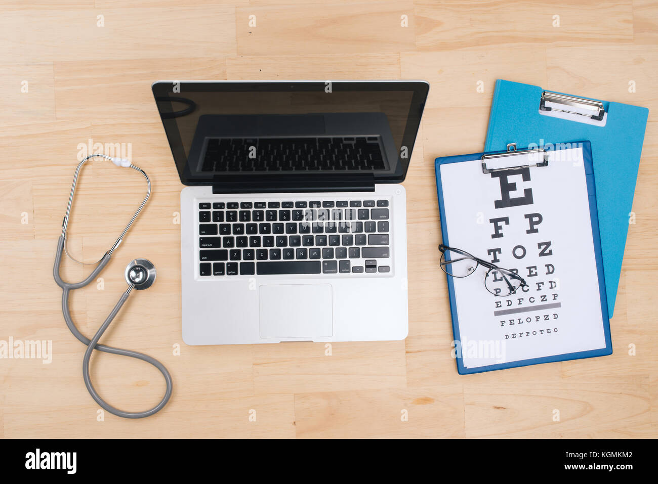 Draufsicht des Doktors Schreibtisch Tisch mit Stethoskop und Notebook mit einem Visual Test Chart Stockfoto