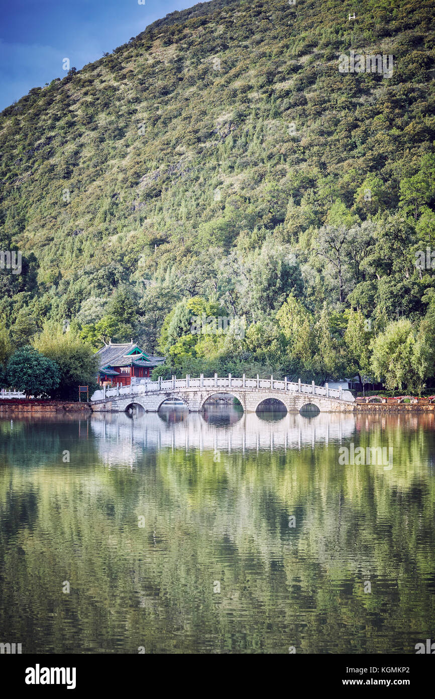Suocui Brücke durch den Pool des Schwarzen Drachens in Jade Spring Park, Farbe getonte Bild, Lijiang, China. Stockfoto