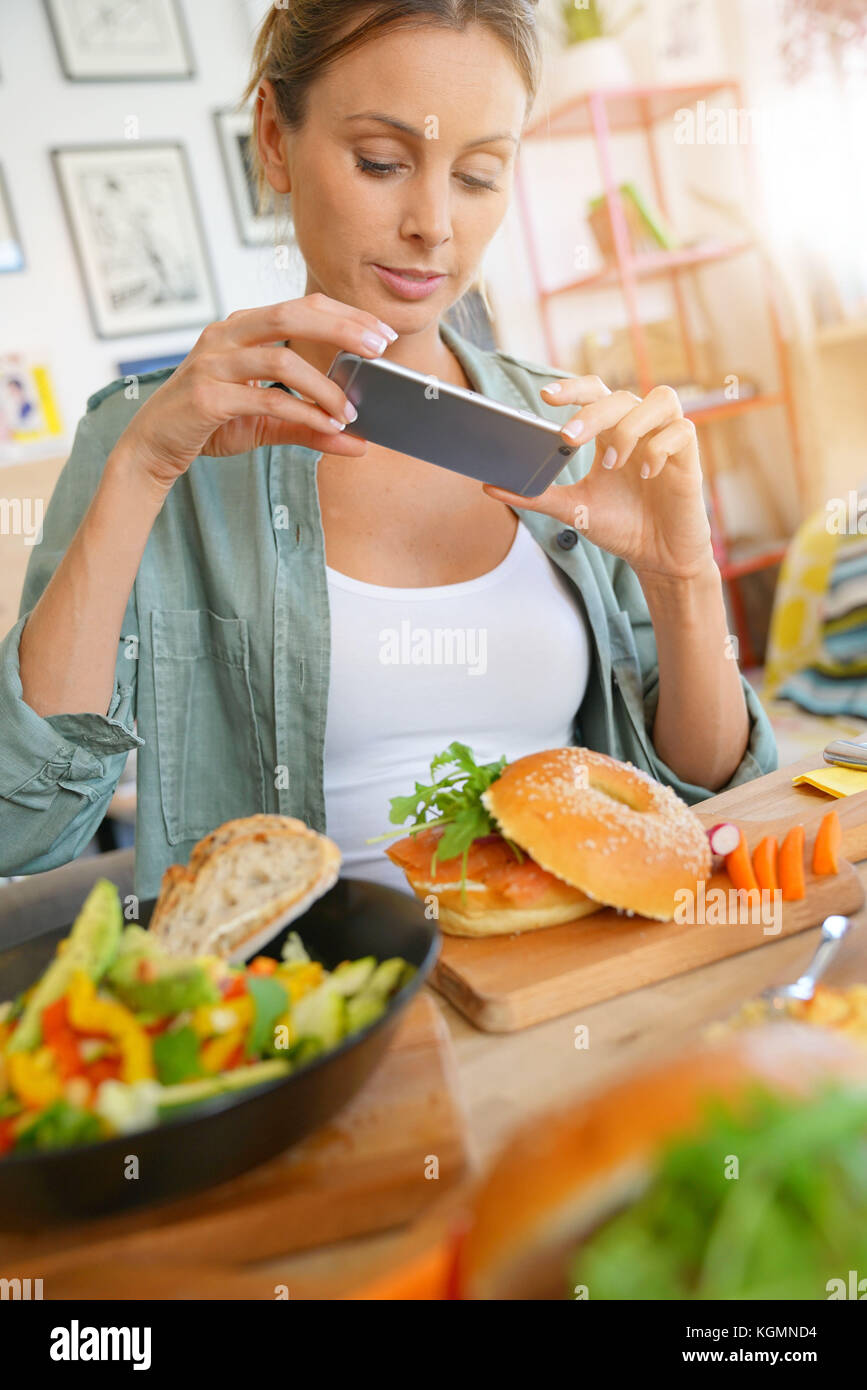 Trendige Mädchen im Restaurant die bunte Teller mit Smartphone Stockfoto