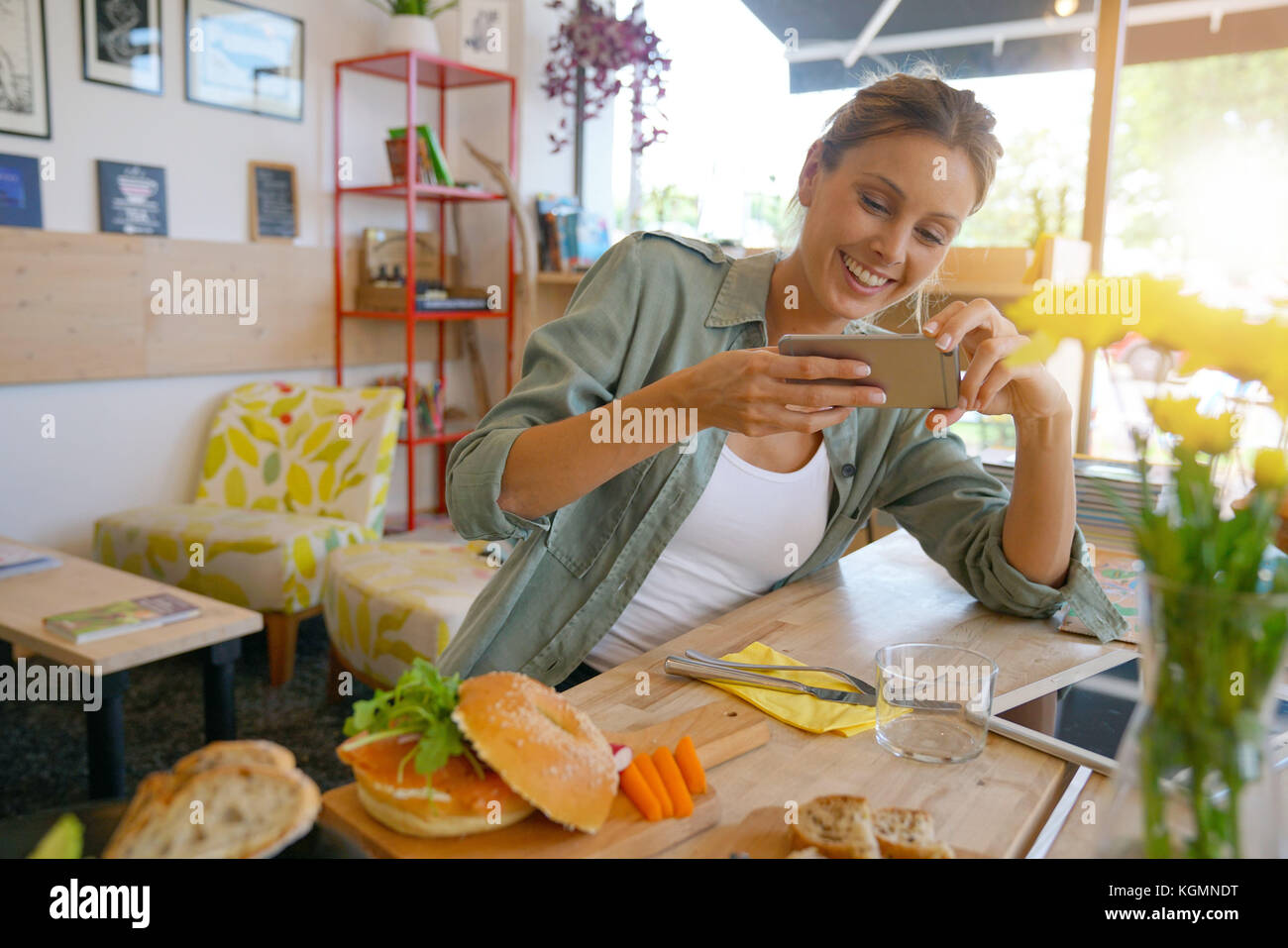 Trendige Mädchen im Restaurant die bunte Teller mit Smartphone Stockfoto