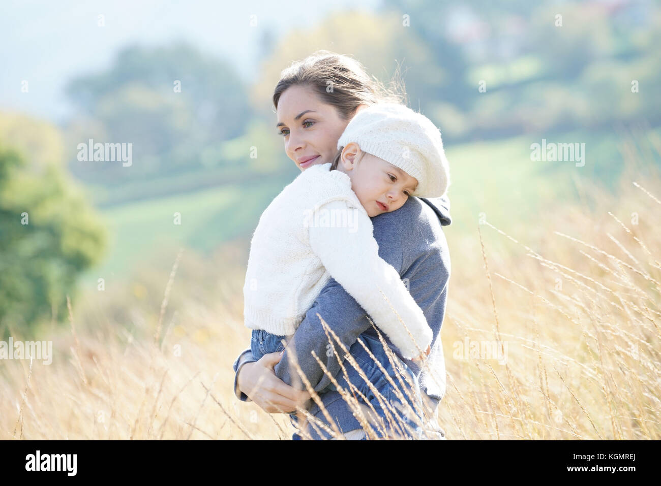 Mama kuscheln kleine Mädchen in den Armen, in der Landschaft Stockfoto