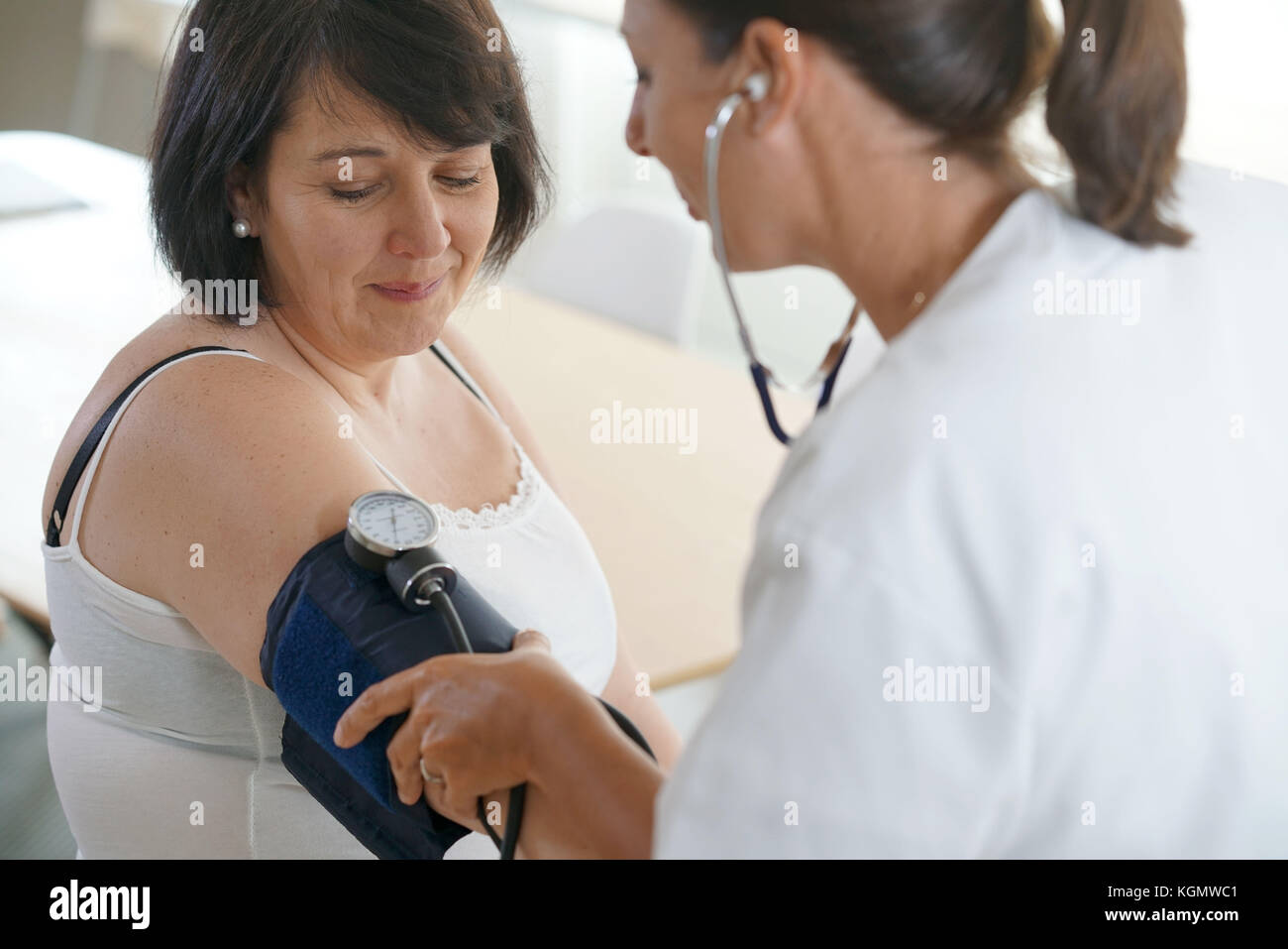 Reife Frau beim Arzt, Controlling Blutdruck Stockfoto