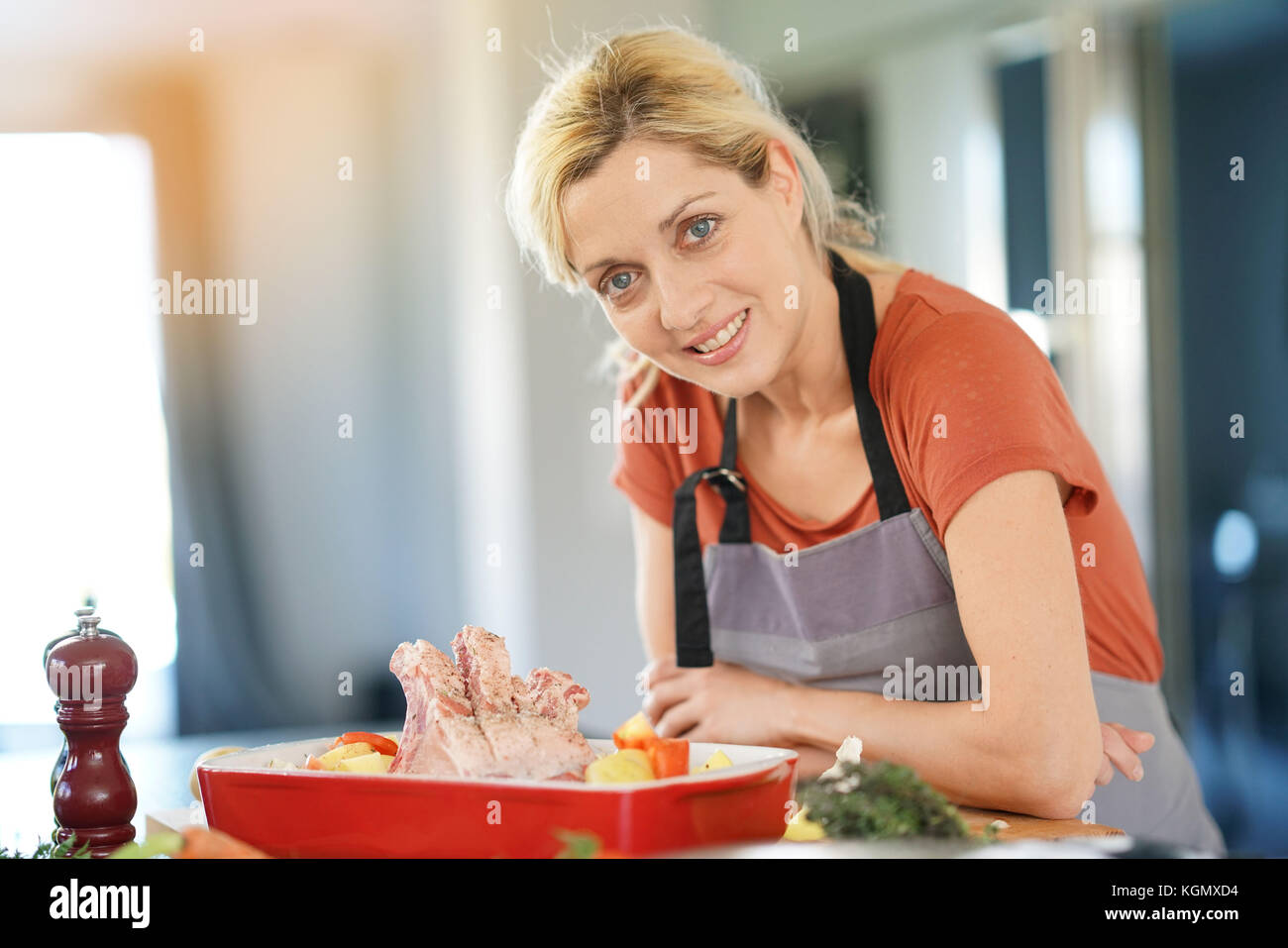 Portrait von lächelnden blonde Frau in der Küche kochen für Abendessen Stockfoto