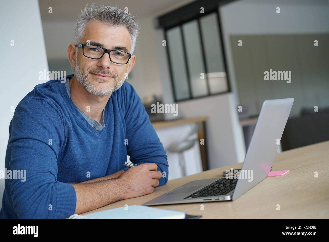 Mann im mittleren Alter, die von zu Hause aus arbeiten - Büro auf Laptop Stockfoto