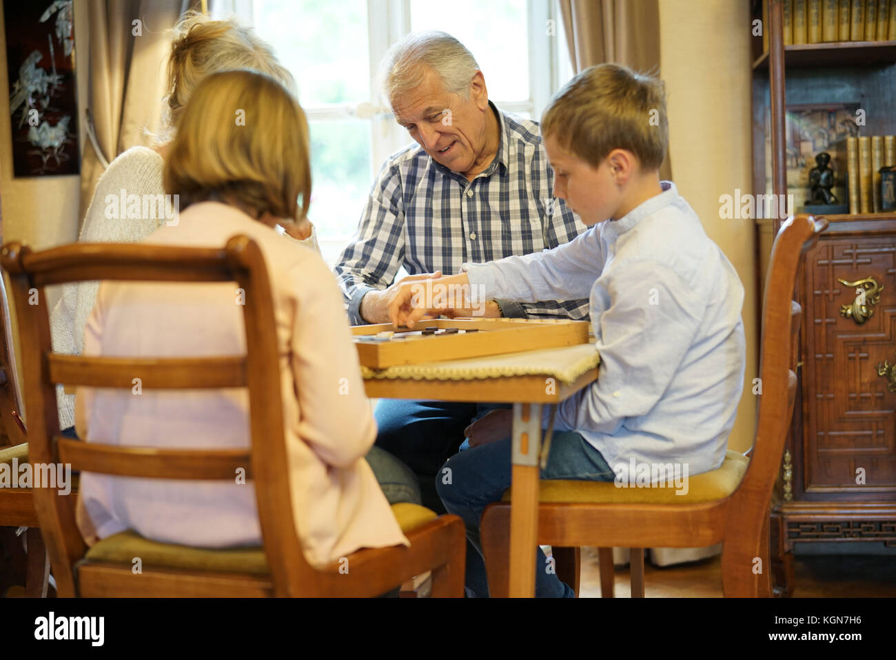 Großeltern mit Enkelkindern spielen Checkers Stockfoto