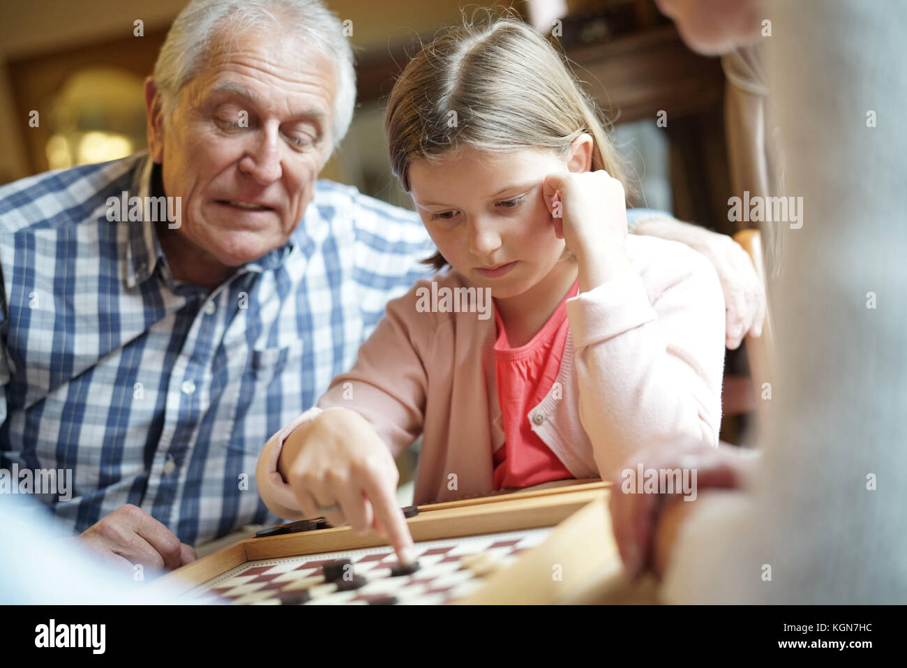 Großeltern mit Enkelkindern spielen Checkers Stockfoto