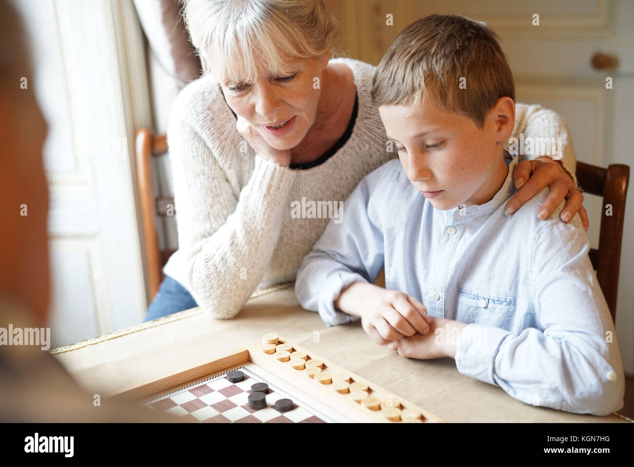 Großeltern mit Enkelkindern spielen Checkers Stockfoto