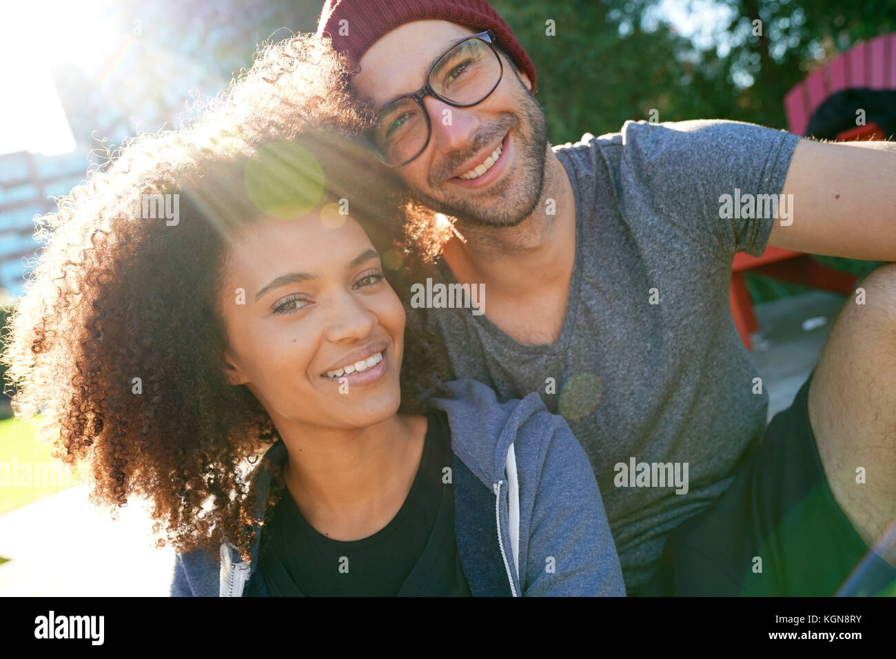 Fröhliche trendige Paar im Park am Morgen sitzen Stockfoto