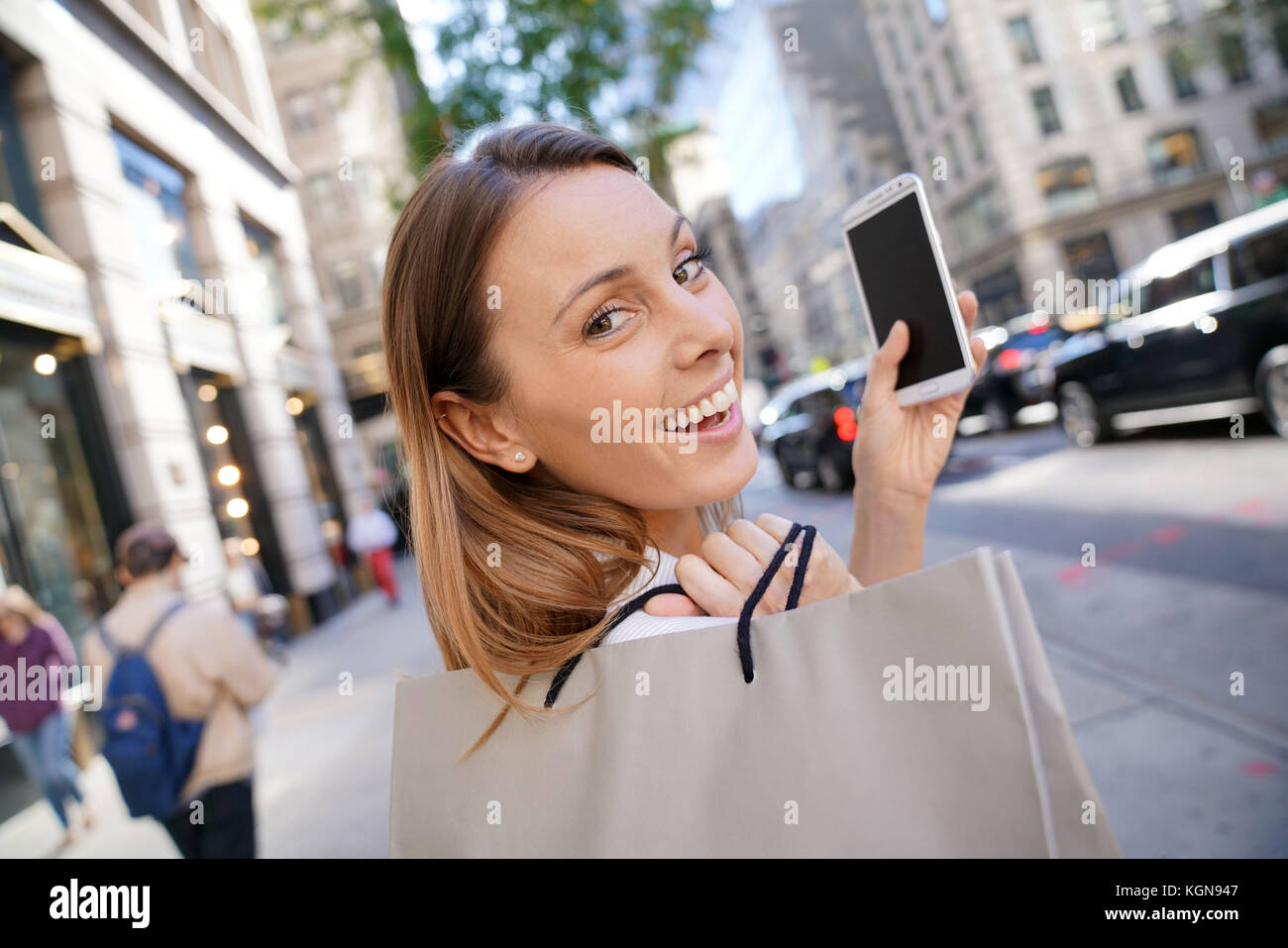 Fröhliches Mädchen shopping in Manhattan und am Telefon sprechen Stockfoto