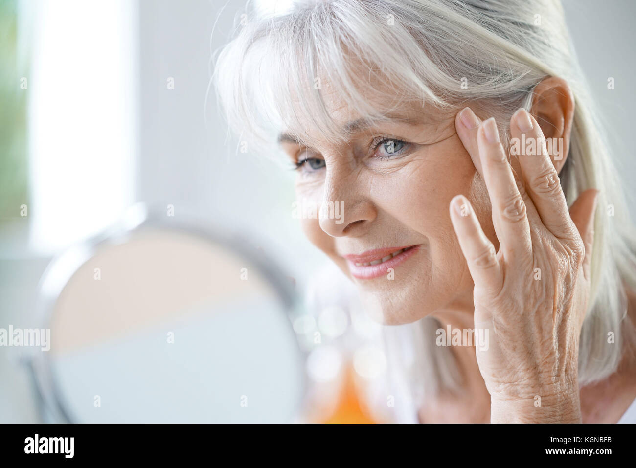 Portrait der älteren Frau Anti-aging-Creme anwenden Stockfoto