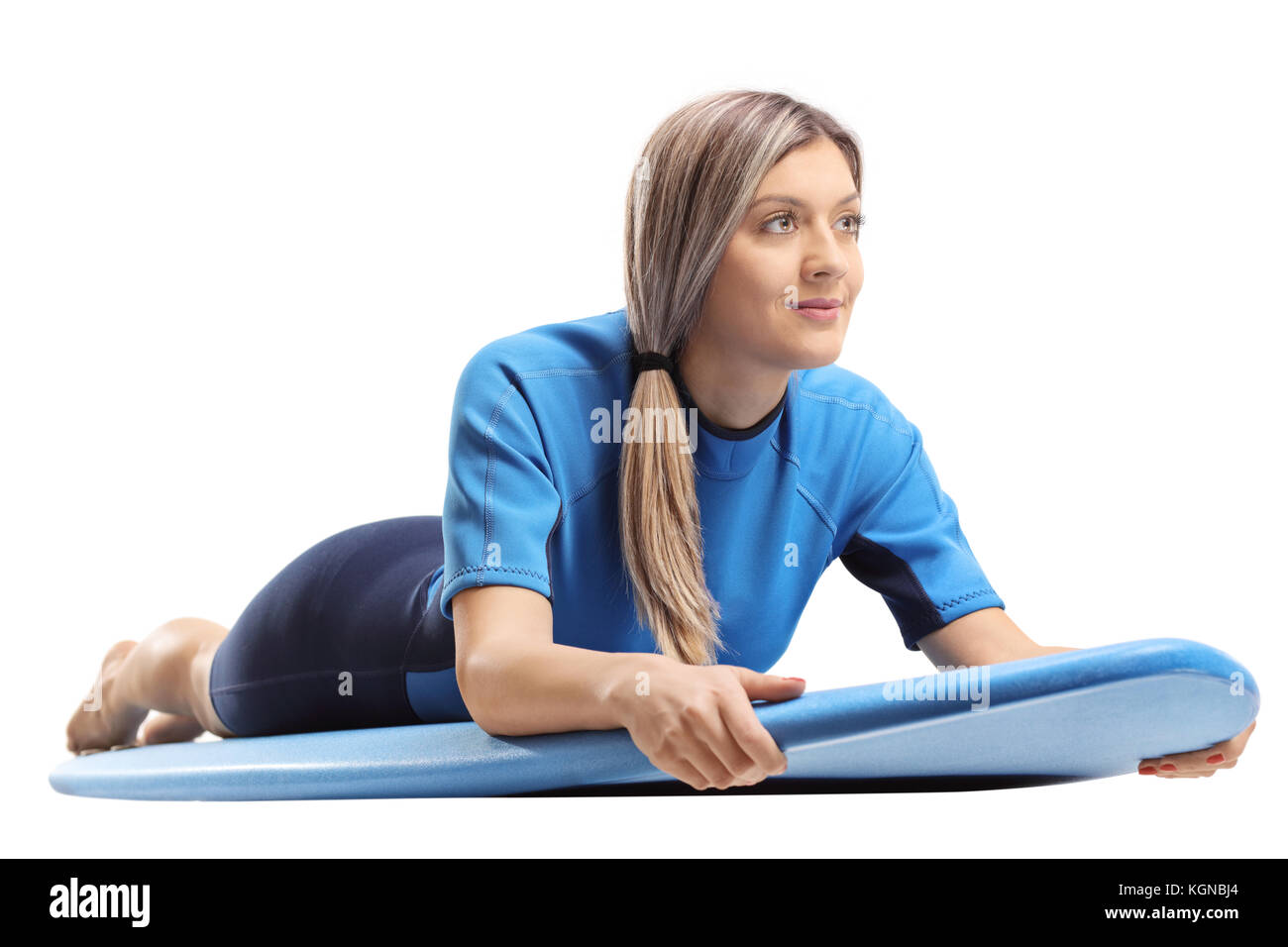 Junge Frau in einem Neoprenanzug liegen auf einem Surfboard auf weißem Hintergrund Stockfoto