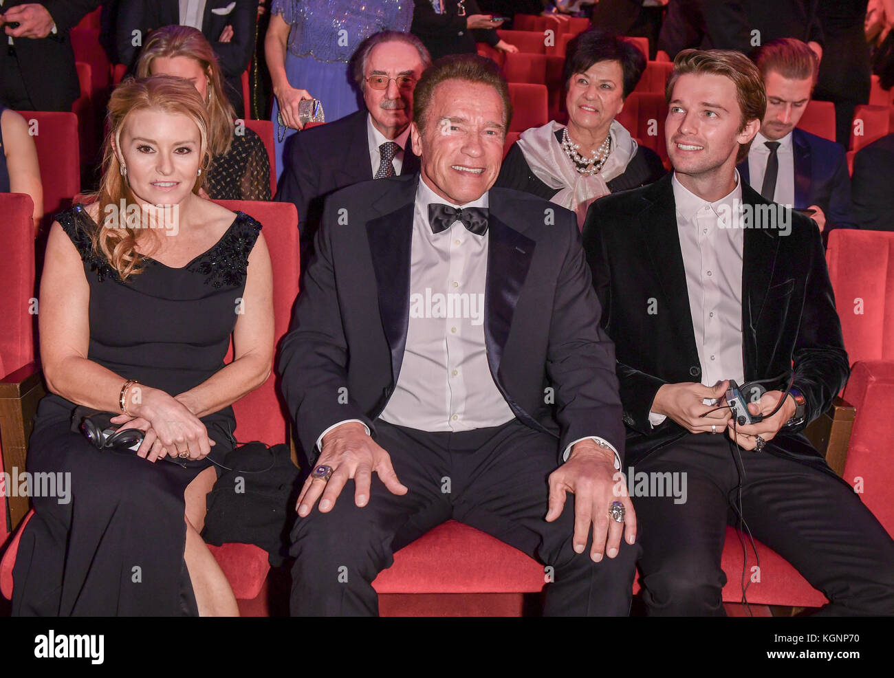 Berlin, Deutschland. November 2017. Arnold Schwarzenegger (C) sitzt zwischen Heather Milligan (L) und seinem Sohn Patrick Arnold Shriver Schwarzenegger während der „GQ Men of the Year“ Award Show am 9. November 2017 in Berlin. Schwarzenegger erhielt den Preis „Legende des Jahrhunderts“. Quelle: Jens Kalaene/dpa-Zentralbild/ZB/dpa/Alamy Live News Stockfoto