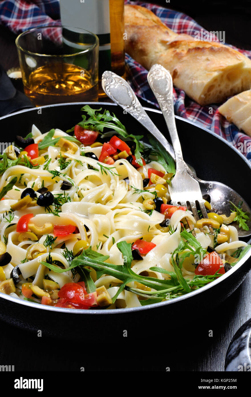 Pasta mit zerdrückten Oliven und Tomaten, Rucola. Vertikale erschossen. Stockfoto