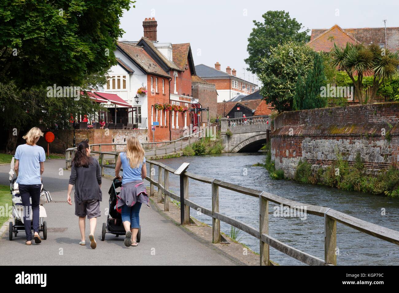 Frauen mit Kinderwagen zu Fuß neben dem Fluss Itchen in Winchester, Hampshire, UK Stockfoto