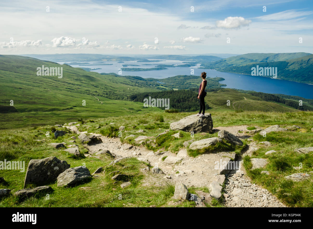 Weibliche Wanderer bewundern die Landschaft auf den Weg zum Gipfel des Ben Lomond an einem sonnigen Tag. Loch Lomond im Hintergrund. Schottland (UK). Stockfoto