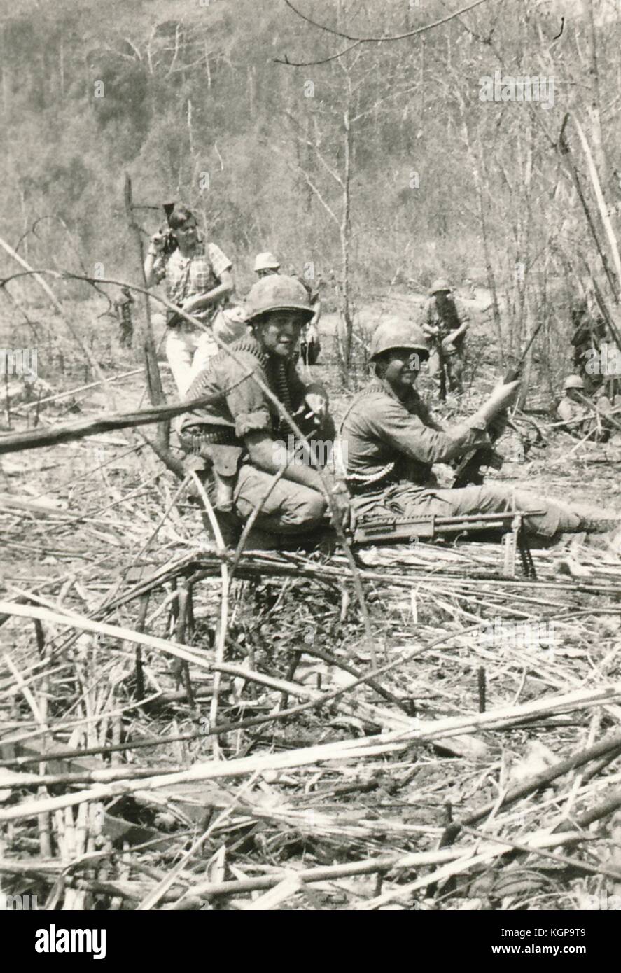 Amerikanische Soldaten mit schweren Maschinengewehren hocken sich während des Vietnamkrieges 1968 in den Dschungel Vietnams. Stockfoto