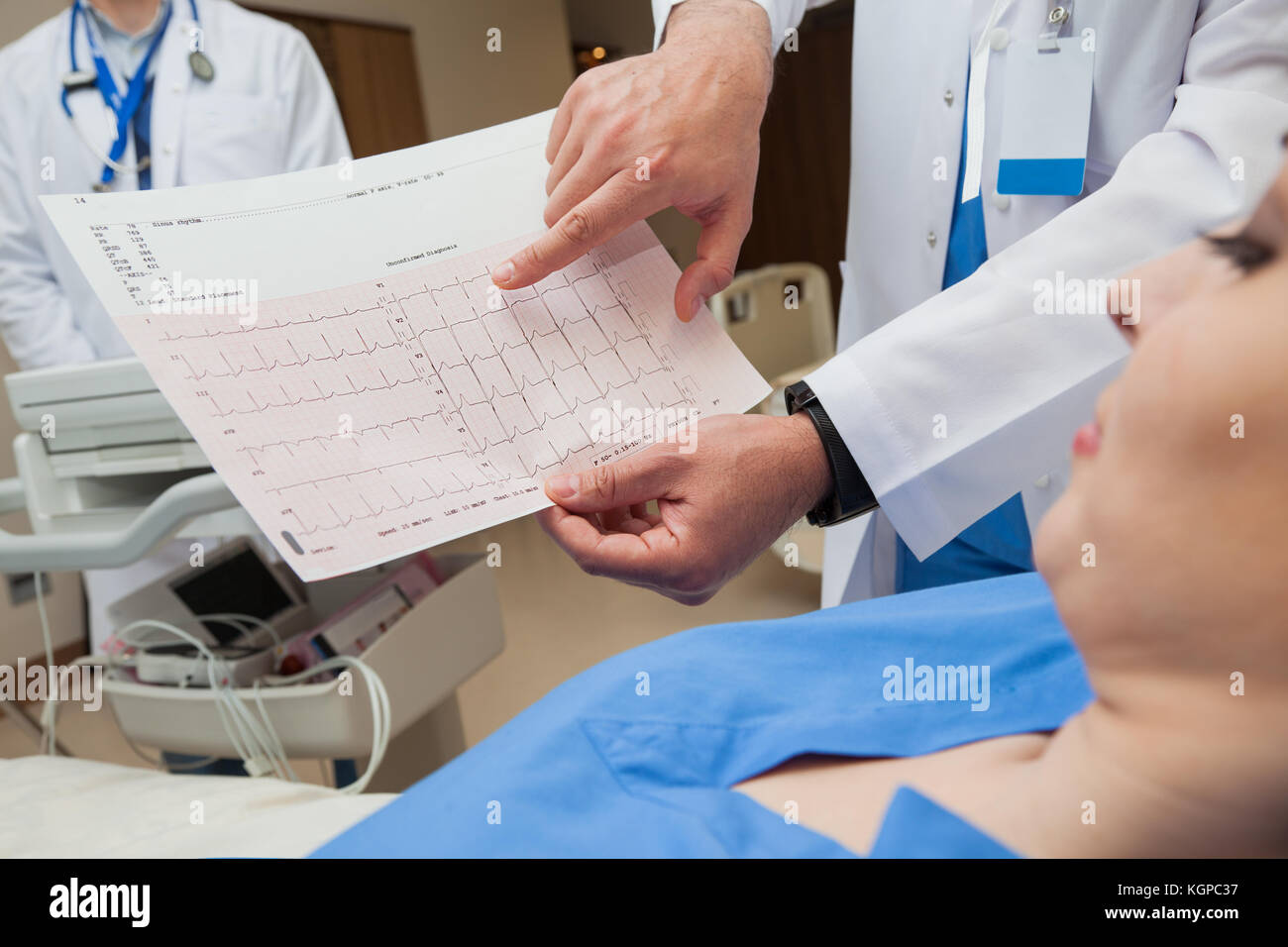 - Ein Arzt in der Nähe, nur Hände, die ein normaler Sinusrhythmus Blatt zu einer jungen Patientin. Stockfoto