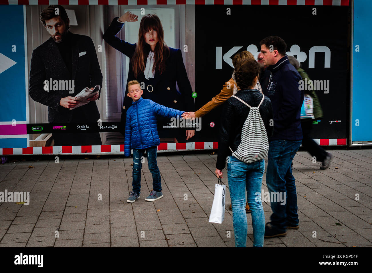 Ein kleiner Junge zerrt an seinen Müttern Arm ungeduldig, während sie spricht mit Freunden (spitalerstraße, Hamburg) Stockfoto