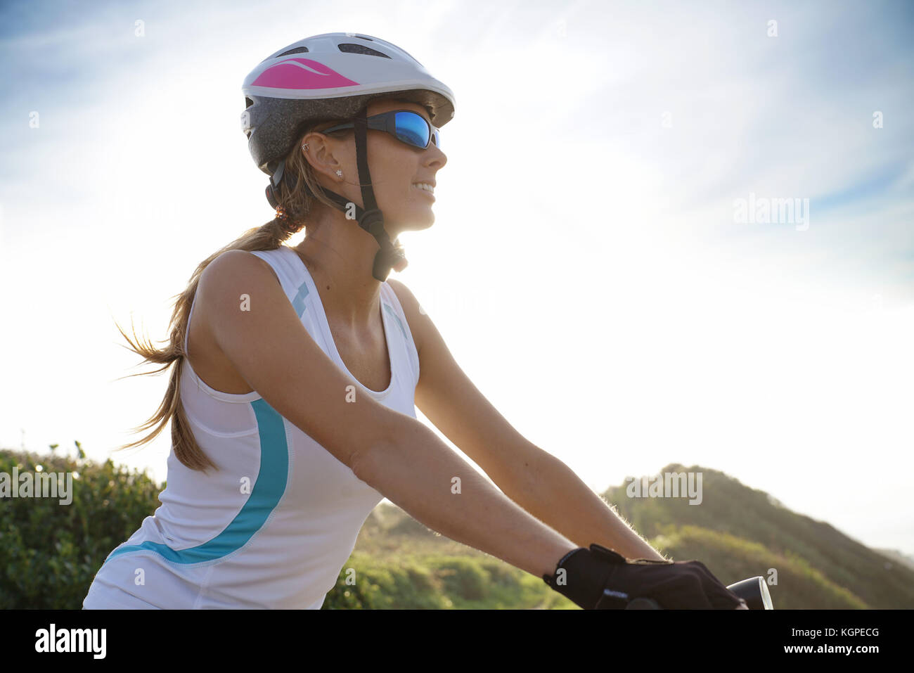 Frau im Sport Outfit Reiten Fahrrad auf Country Track Stockfoto